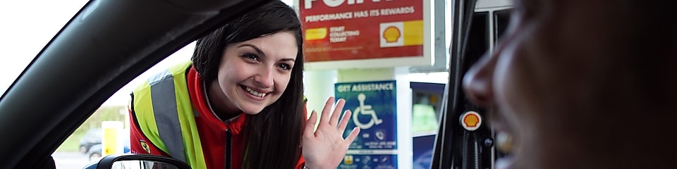 A woman at shell station helps a disabled man to refuel his car