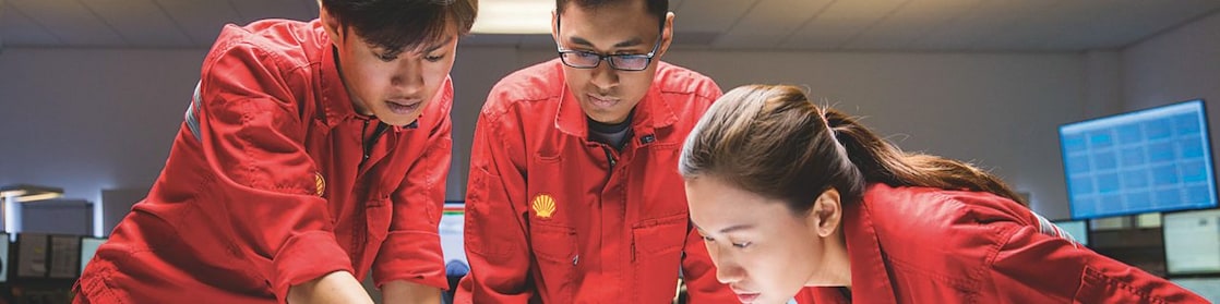 Three employees reviewing plans