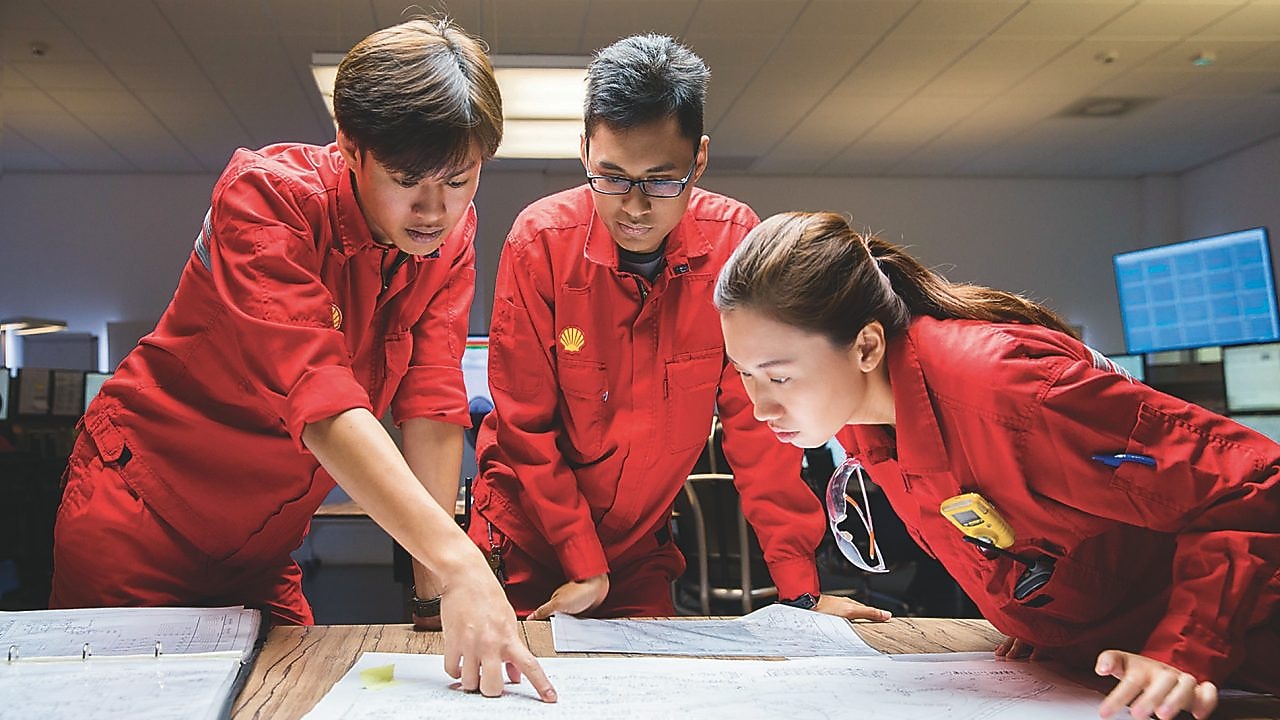 Three employees reviewing plans