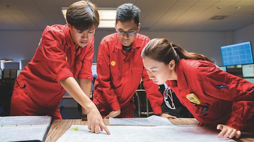 Three employees reviewing plans