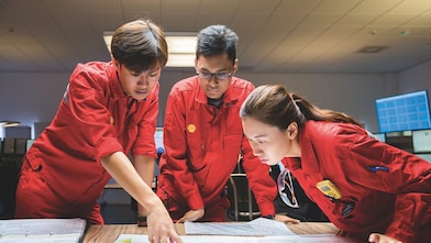 Three employees reviewing plans