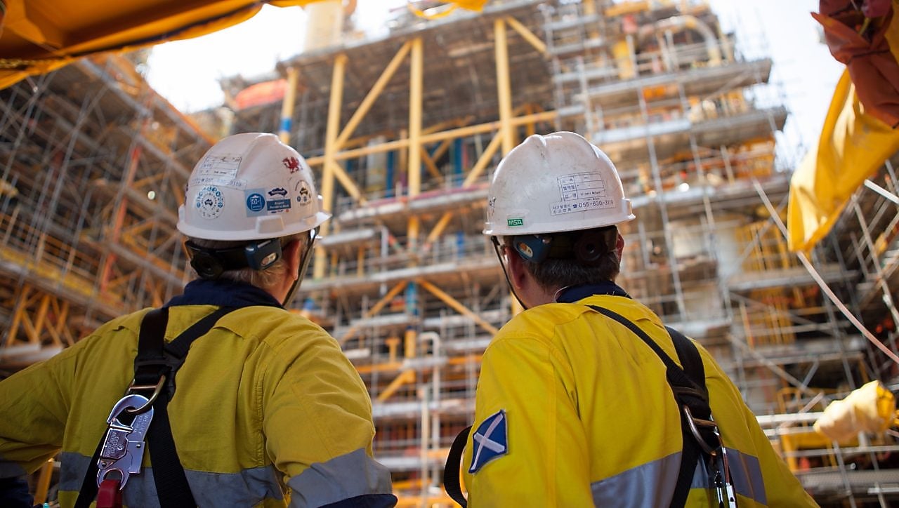 Two men looking at construction of a platform