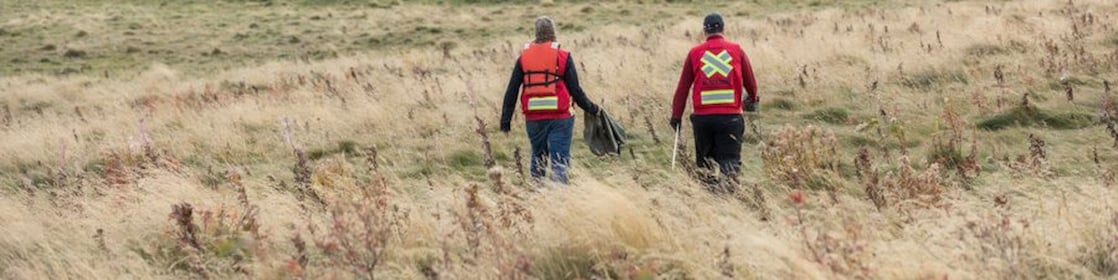 Two people walk towards a pond