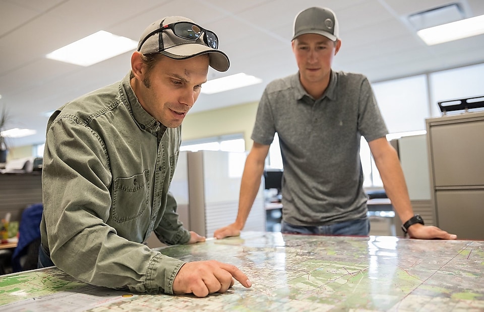 Shell employees consult a map of Groundbirch operations