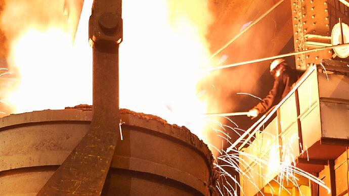 Worker in full PPE working in steel mill