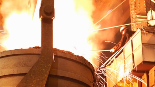 Worker in full PPE working in steel mill