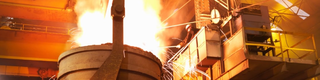Worker in full PPE working in steel mill