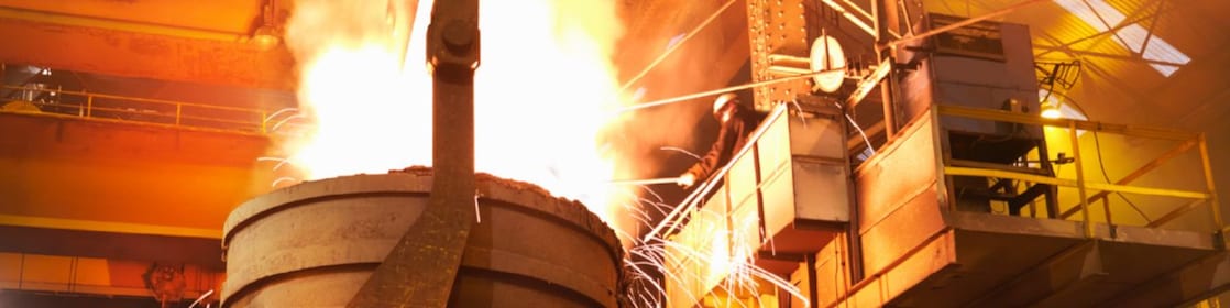 Worker in full PPE working in steel mill