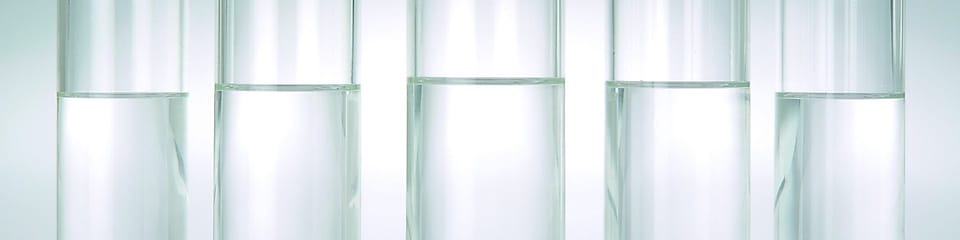 Five beakers in a row with a clear liquid in each one