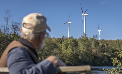 Man looking at mount storm wind turbines