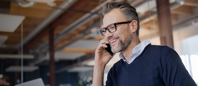 Man looking at his laptop and talking on his cellphone