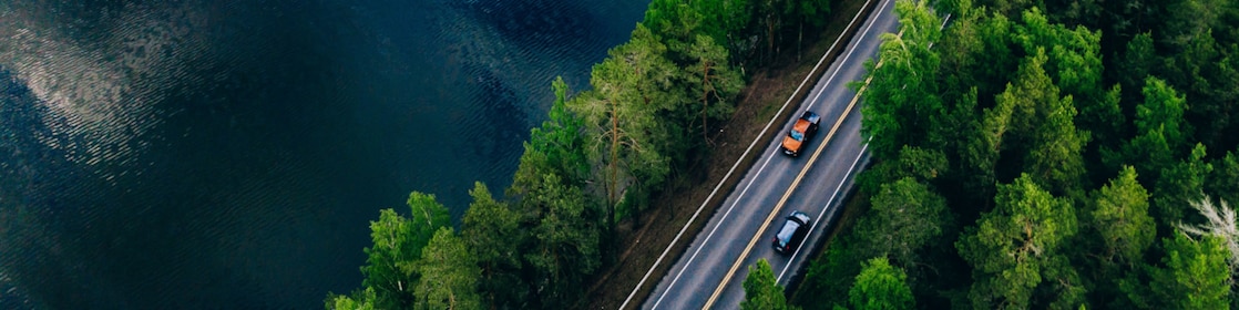 Cars moving on road adjacent to lake