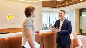 Two colleagues talking in a corporate reception area