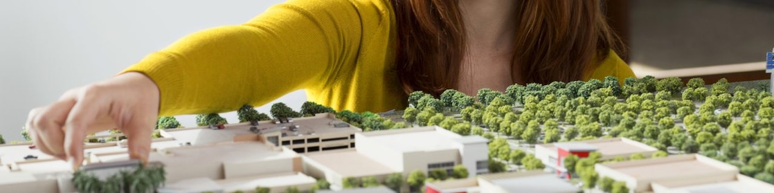 Caucasian businesswoman examining scale model