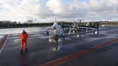 man walking beside a mechanical unit