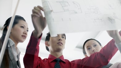man showing bluprint to colleagues