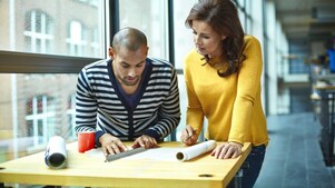 Two architects discussing project at high table