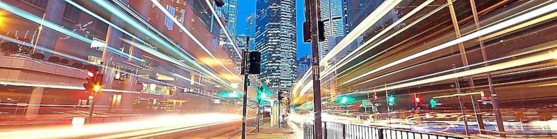 A city scape at night with trailing lights from cars going by.