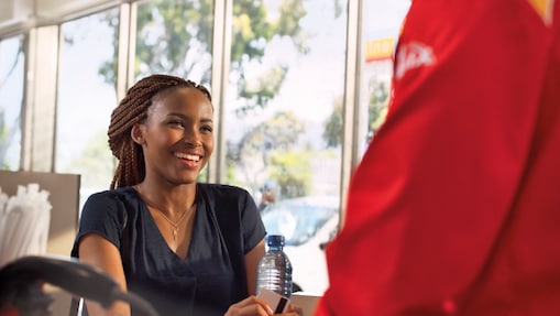Female customer smiling at a Shell retail station.