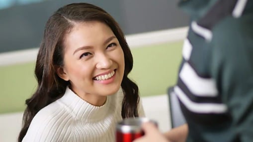 Female Shell employee looking up at a colleague and smiling.