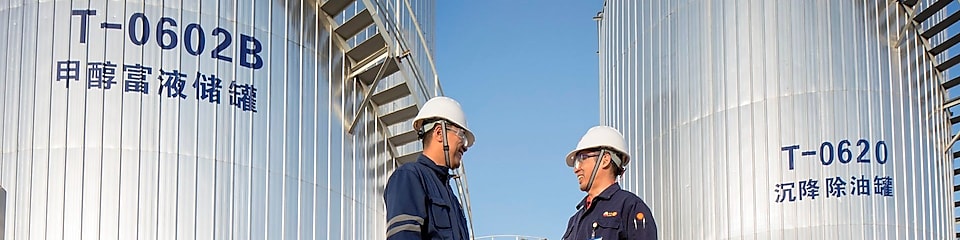 Two Asian Shell engineers meeting at an operational site.