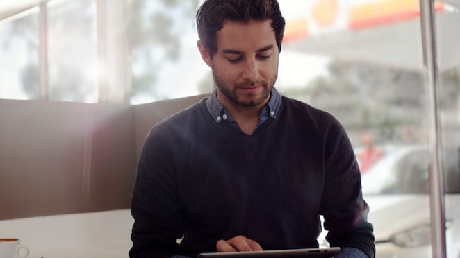 a man busy with tablet holded on his hand