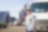 Truck driver with the shipping container and truck in the background
