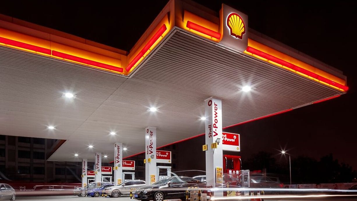 Shell service station at night with bright canopy lights and Shell V-Power fuel pumps.
