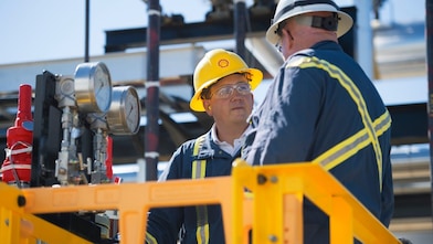 two employees wearing yellow and white shell cap