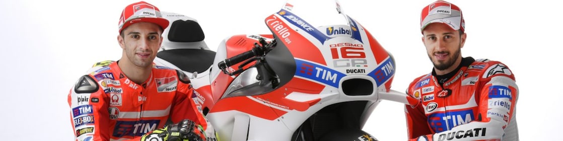 Two Ducati 2016 riders sitting next to a Ducati motorcycle