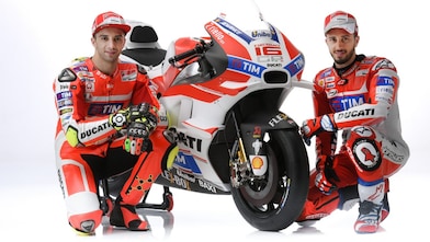 Two Ducati 2016 riders sitting next to a Ducati motorcycle