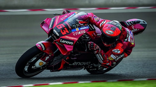 A red Ducati MotoGP bike taking a sharp turn on a race track