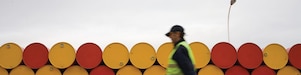 man walking barrels lubricants
