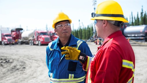 two Shell employees talking on the field