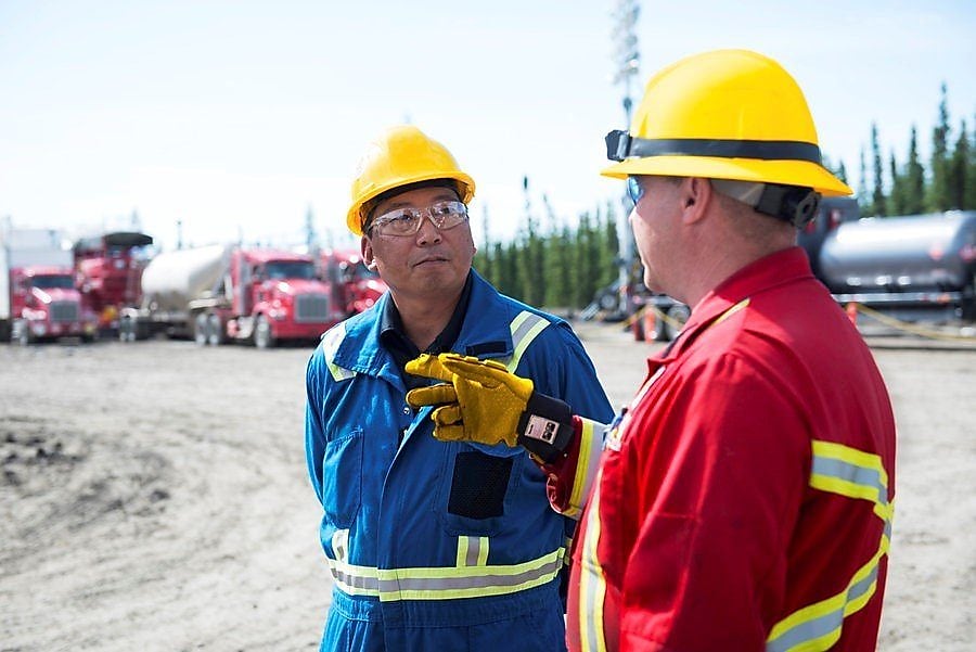 two Shell employees talking on the field