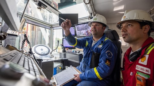 Two engineers in hard hats viewing information on tablets