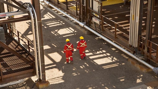 Travailleurs se tenant devant l'unité Quest de captage et de stockage du carbone sur le site de Shell Scotford