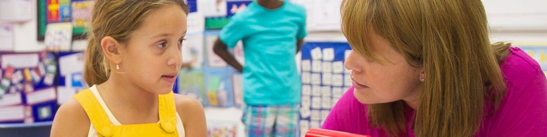 Un enseignant aide un enfant à faire son travail de classe.