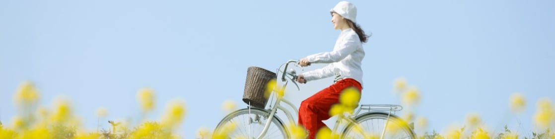 Une jeune femme fait une promenade à vélo dans un champ en été