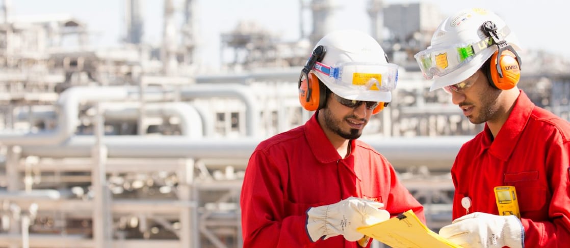 Two Shell worker at a petrochemical plant reviewing documentation