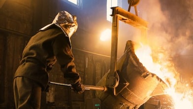 Steel mill worker dumping molted steel from a container