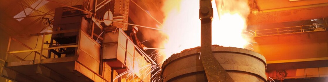 workers watching heavy machinery in a metal processing plant