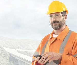 man wearing a yellow safety helmet holding a phone