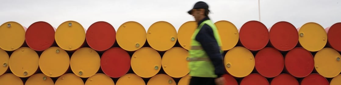 Man walking barrels lubricants