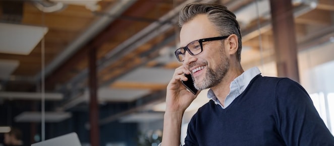 Man looking at his laptop and talking on his cellphone