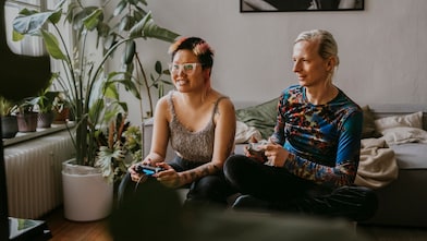 two people playing video games together at home