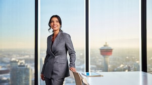 professional standing in a modern office with city skyline view
