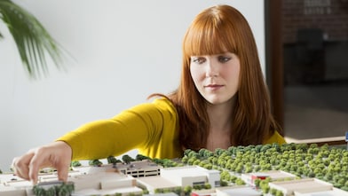 Une femme d’affaires caucasienne examine un modèle réduit