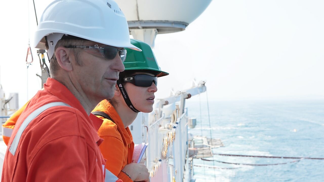 man and woman watching from ship