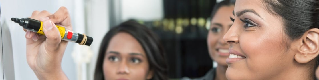 Un chef d’entreprise écrit sur un tableau blanc